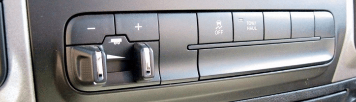 Close-up of vehicle dashboard controls, including a trailer brake adjustment and tow/haul button.