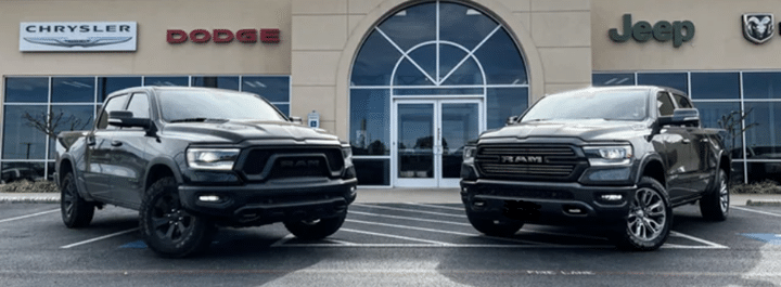 Two Ram trucks parked in front of a Chrysler, Dodge, Jeep dealership.