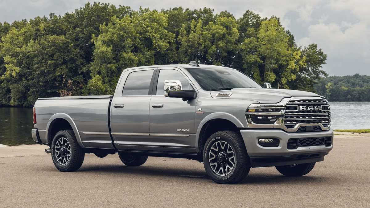 Silver pickup truck parked by a lake with trees in the background, showcasing rugged design.