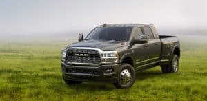 A rugged pickup truck parked on a grassy field with a foggy backdrop.
